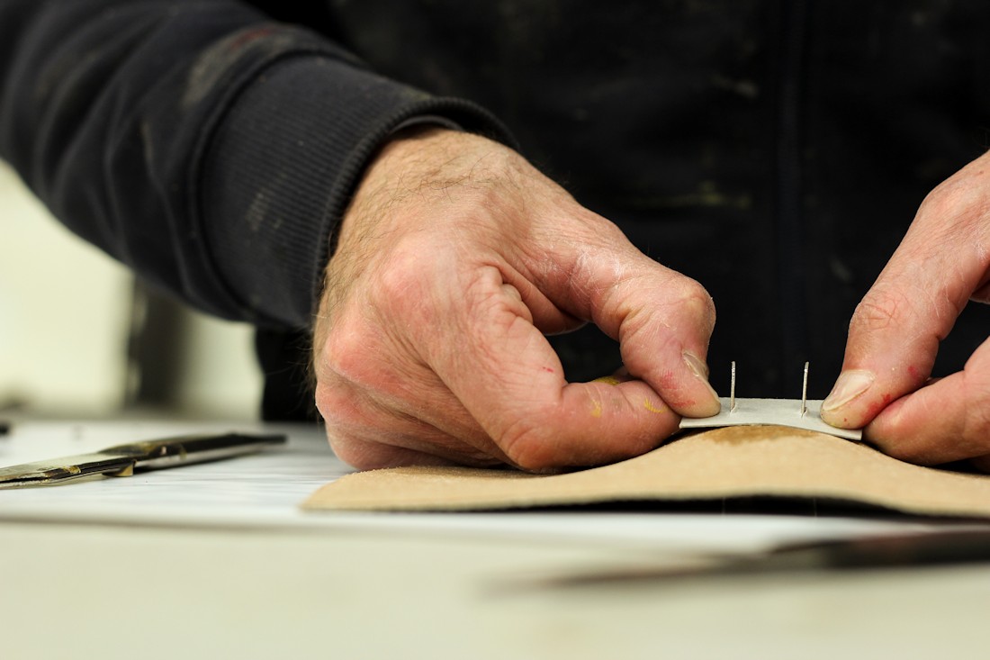The hands of a Del Giudice Roma craftsman making sustainable leather bags
